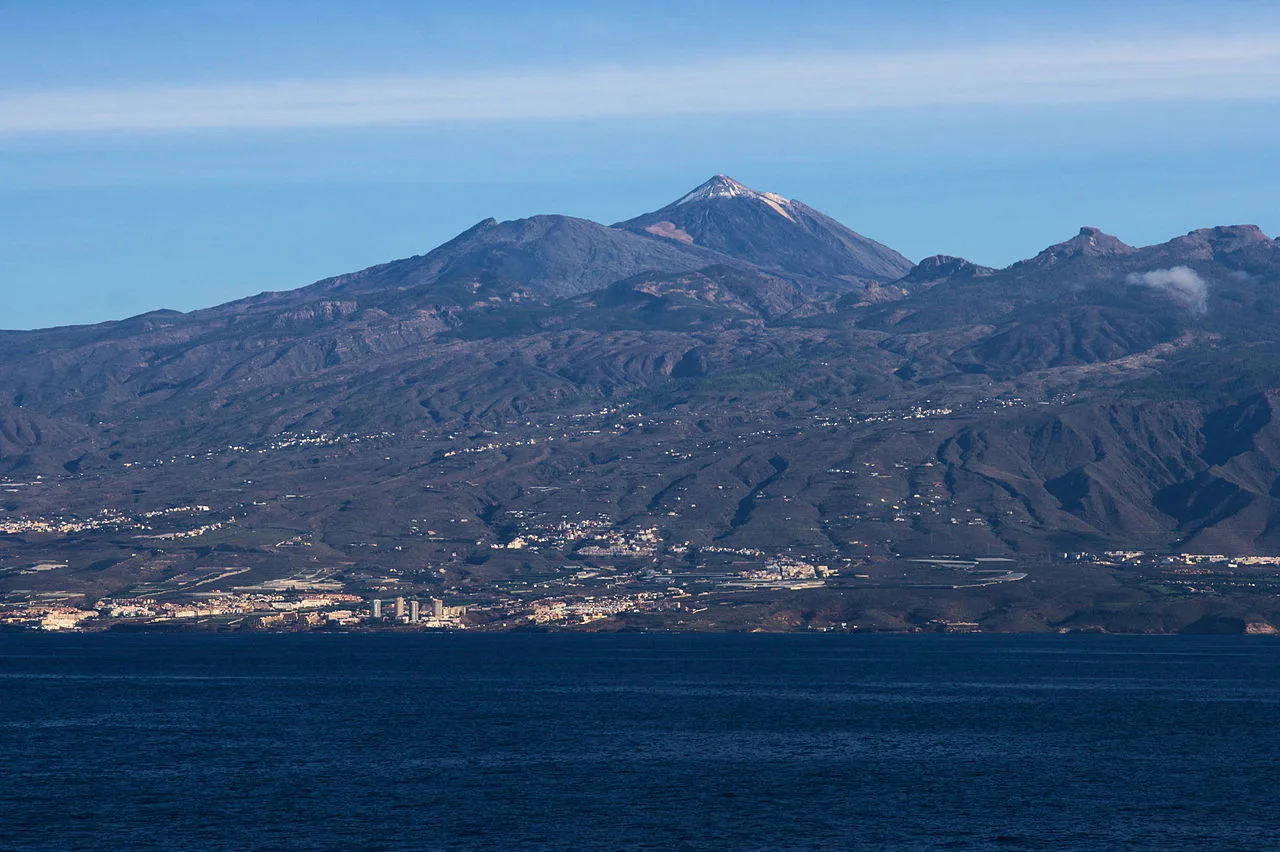 Kustlijn van Costa Adeje gezien vanuit zee, met de heuvels van het historische Adeje op de achtergrond
