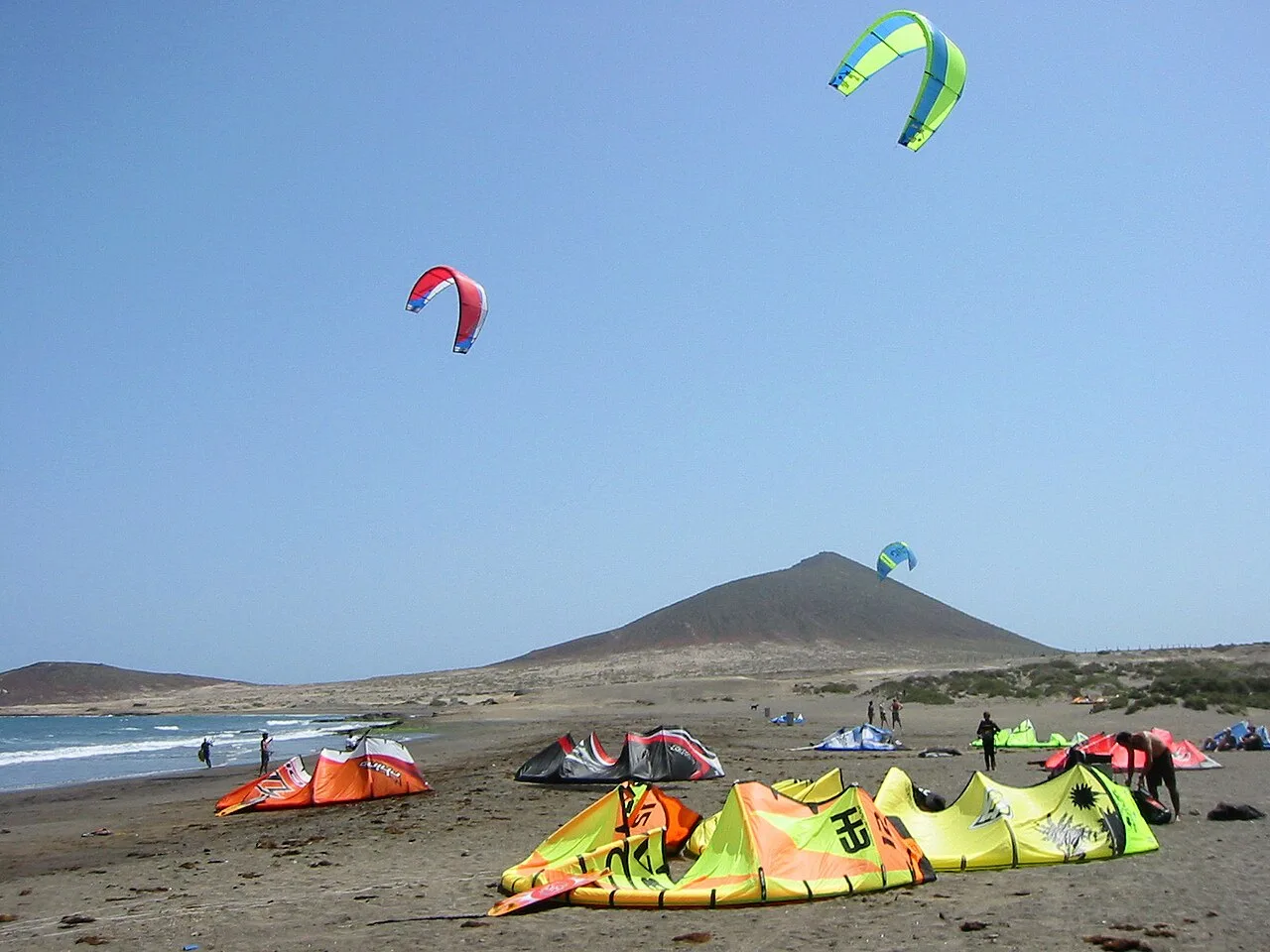 Kitesurfers op het strand van El Médano met de Montaña Roja op de achtergrond, Tenerife