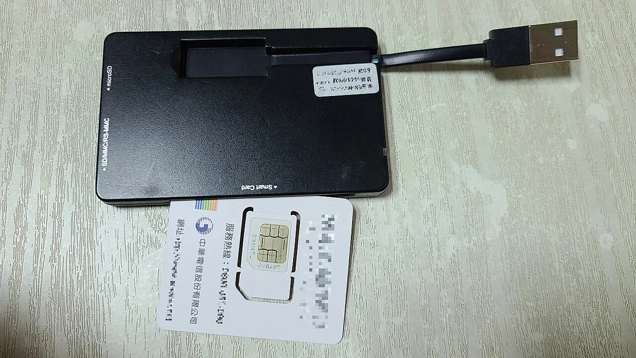 Fysieke simkaart en kaartlezer naast smartphone